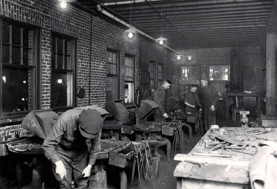 1922 photograph of College of Engineering. Students working in the forge shop. [PG1_224-10]
