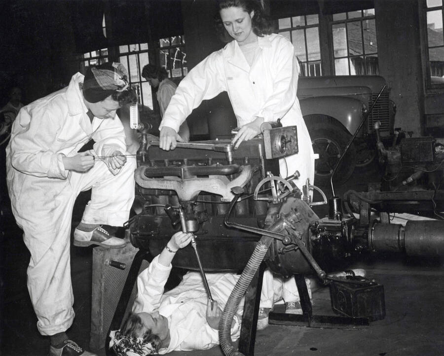 1944 photograph of College of Engineering. Female students work on an enigne for the Women's auto mechanics course during World War II. [PG1_224-22]
