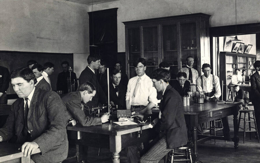 1907 photograph of College of Engineering. Students work at lab tables during electrical engineering class. [PG1_224-27]