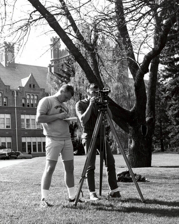 1964 photograph of College of Engineering. Students surveying in front of the Administration building. Donor: Publications Dept. [PG1_224-32]