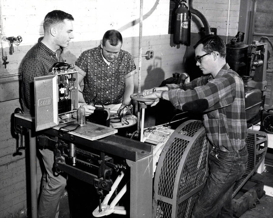 1962 photograph of College of Engineering. Dean Kohntopp, Ralph Brown, Allan Ross analyze exhaust gases in a laboratory. Donor: Publications Dept. [PG1_224-33]