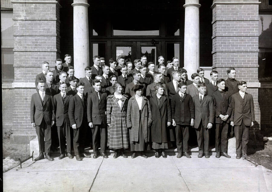 1917 photograph of Short course students. School of Practical Agriculture and Household Arts group photo in front of a building. [PG1_234-01]