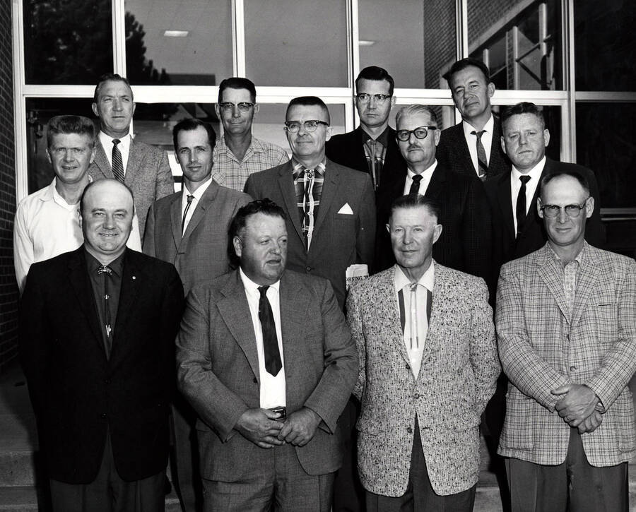 1960 photograph of Agricultural Extension Service. First row l to r: Earl McClellan, Milton Branch, Grover Jensen, Marion Holben. Second row l to r: Vernon Burlison, Jack Fry, John Ludke, C.O. Youngstrom, R.D. Ensign. Third row l to r: Lee Morgan, Harold Snow, Bill Scribner, Mel Carlson. Donor: Univeristy of Idaho Cooperative Extension System. [PG1_237-12]