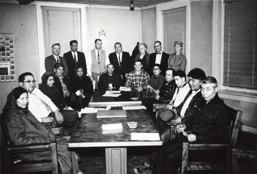1958 photograph of Agricultural Extension Service. Seated, l to r: M. Farner, Mr. Parker, J. Eagle, R. Pokibro, Mrs. Pokibro, J. Cutler, G. Kunkel, Mrs. Blackhawk, L. La Vatta, L. Sorrell, J.Trimo? E. Boyer. Standing l to r: T. J. Chester, Pensureau, A. Anderson, F. Owl, C. Farrar, C. Youngstrom. Donor: University of Idaho Cooperative Extension System. [PG1_237-13]