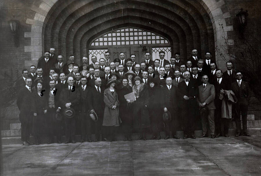 1923 photograph of Agricultural Extension Service. Conference group photograph in front of the Administration building. Includes: 1. President Upham 2. Dean Iddings 3. Mr. Kjosness 4. Mr. Atkinson 5. Miss Verna Johannassen. [PG1_237-02]
