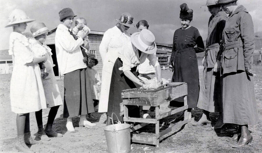 1916 photograph of Agricultural Extension Service. Poultry killing/culling demonstration. [PG1_237-07]
