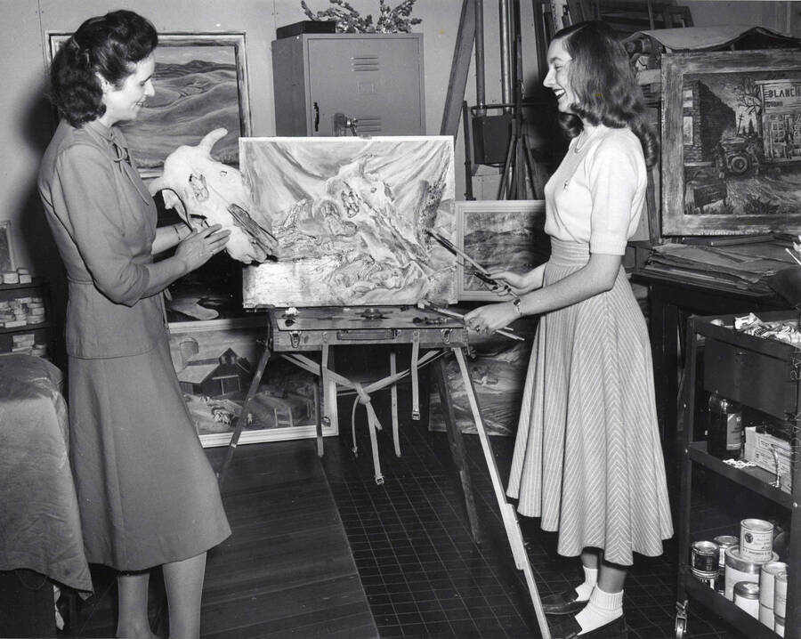 1951 photograph of Art and Architecture. Mary B. Kirkwood and two students examining paintings in a studio. Donor: Publications Dept. [PG1_241-26]