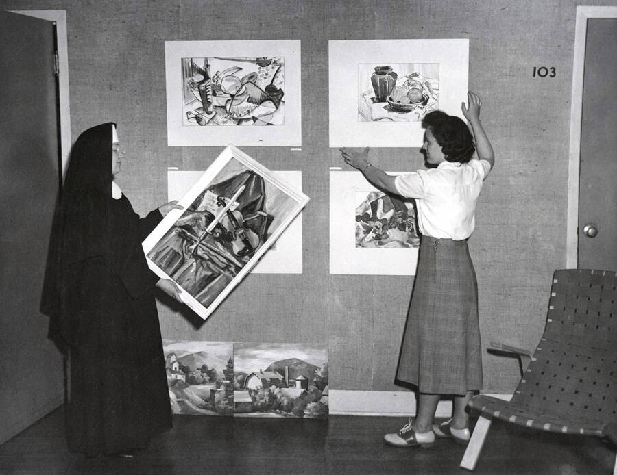 1936 photograph of Art and Architecture. Students hang paintings for an exhibit. Donor: Publications Dept. [PG1_241-27]