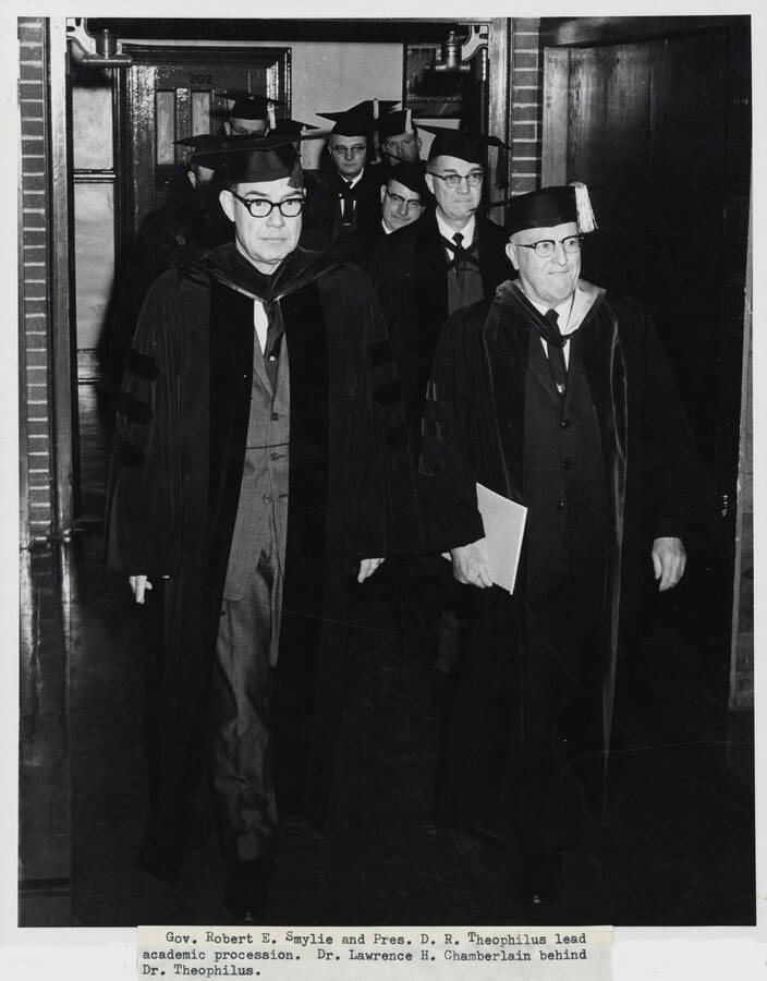 1964 photograph of 75th Anniversary. Governor Robert E. Smylie and President D.R. Theophilus in academic regalia leading a procession. [PG1_246-01a]