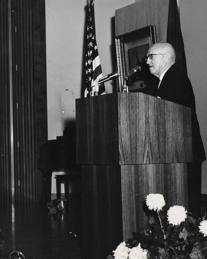 1964 photograph of 75th Anniversary. President D. R. Theophilus giving a speech at a lectern. [PG1_246-06c]