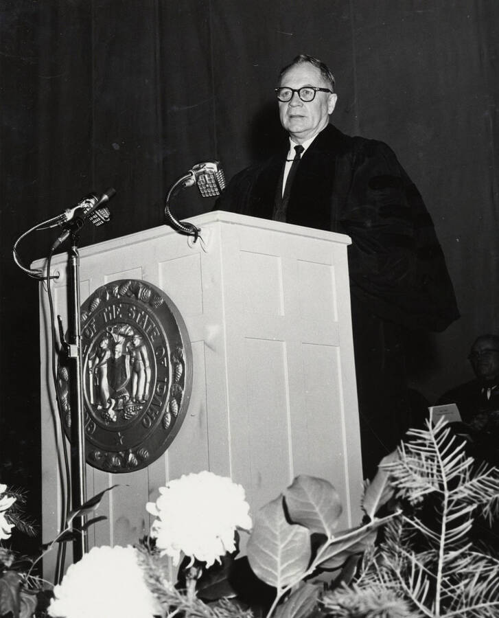 1964 photograph of 75th Anniversary. Regent Ezra M. Hawkes giving a speech at a lectern [PG1_246-08a]