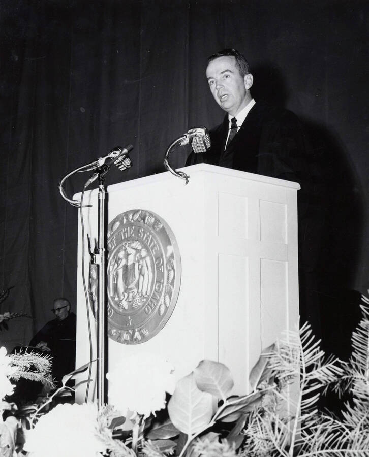 1964 photograph of 75th Anniversary. Alumni Association president James H. Roper giving a speech at a lectern. [PG1_246-10a]