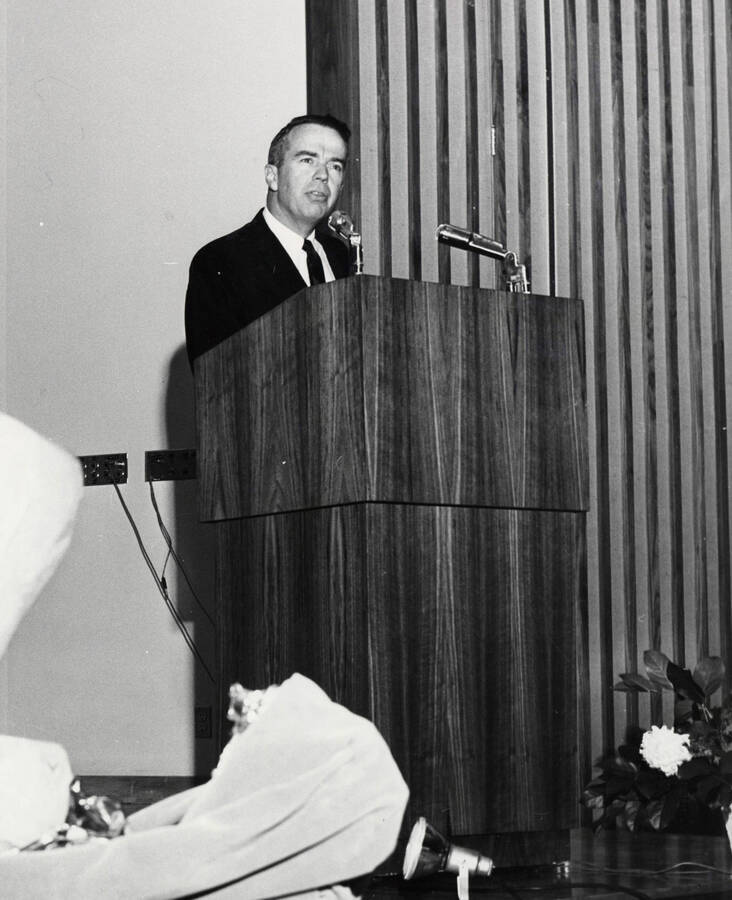 1964 photograph of 75th Anniversary. Alumni Association president James H. Roper giving a speech at a lectern. [PG1_246-10b]