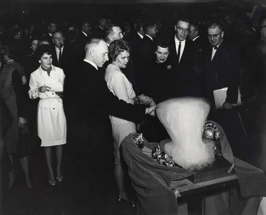 1964 photograph of 75th Anniversary. Faculty looking at an ice sculpture during the 75th Anniversary. [PG1_246-14]
