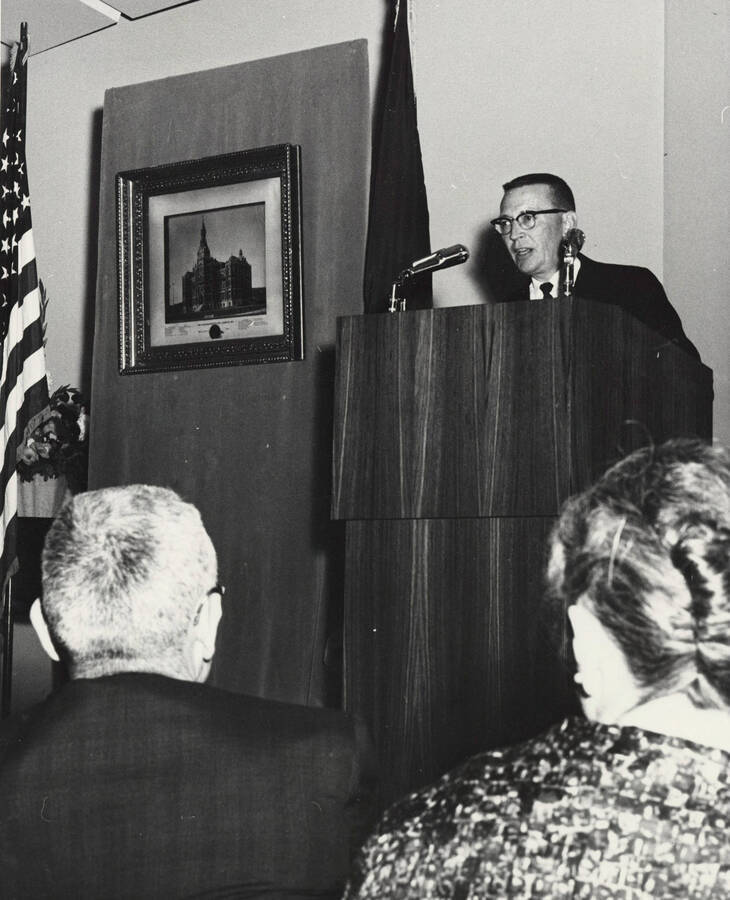1964 photograph of 75th Anniversary. A speaker at a podium during the 75th Anniversary. [PG1_246-15]
