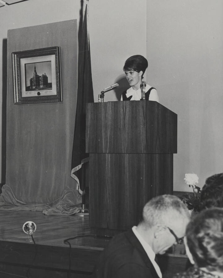 1964 photograph of 75th Anniversary. A speaker at a podium during the 75th Anniversary. [PG1_246-16]