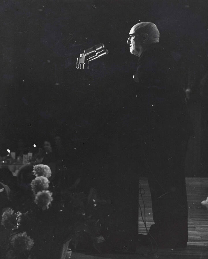 1964 photograph of 75th Anniversary. President D.R. Theophilus giving a speech from a lectern. [PG1_246-6a]