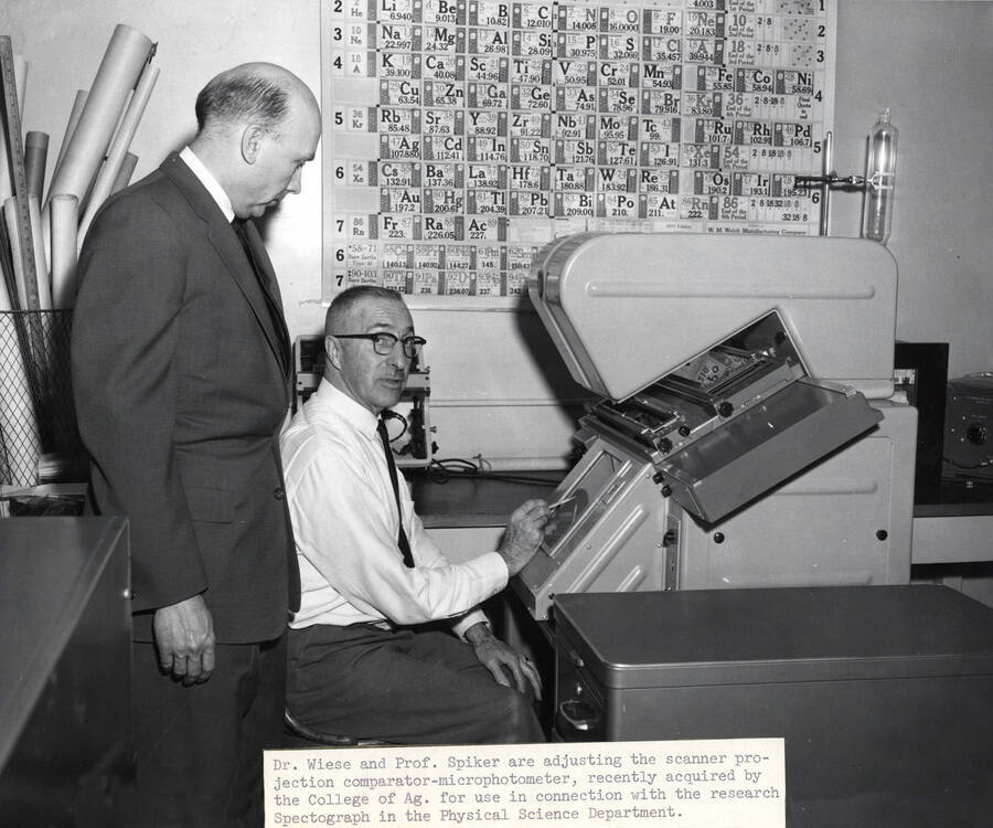 1960 photograph of Physical Sciences. Dr. Alvin Wiese and professor Emmett Spiker adjusting the scanner projection comparator-microphotometer. Donor: Photo Center. [PG1_248-01]