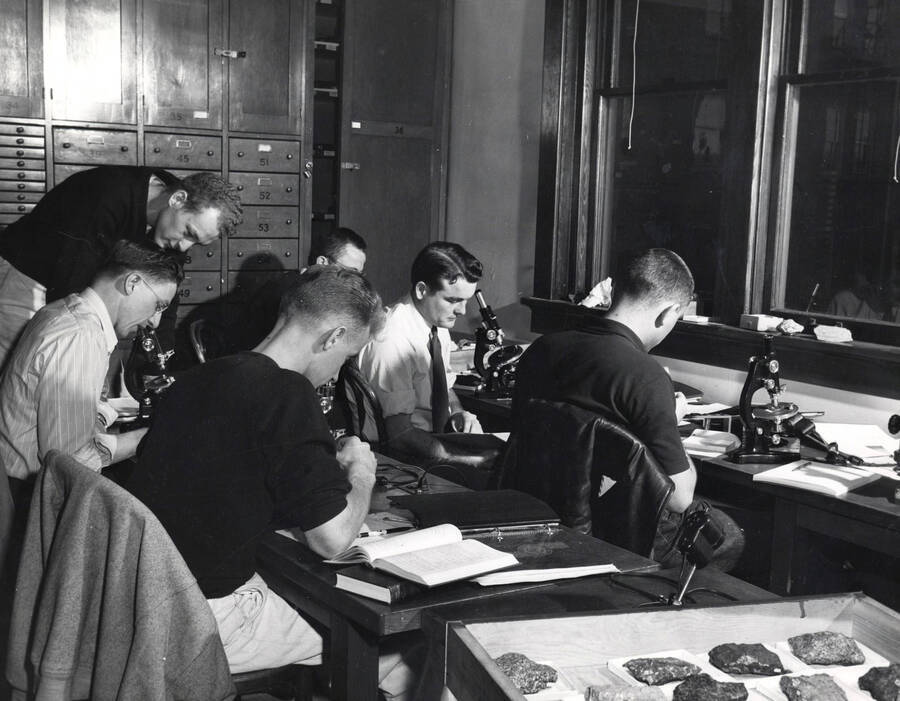 1950 photograph of Geology. Students study rock samples in the geology lab. Donor: Publications Dept. [PG1_250-10]