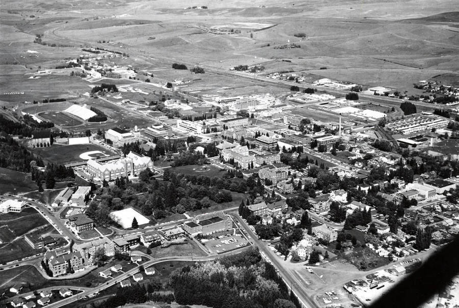 1963 photograph of University of Idaho campus. Aerial view shows both campus and the surrounding fields. Donor: Publications Dept. [PG1_003-27]
