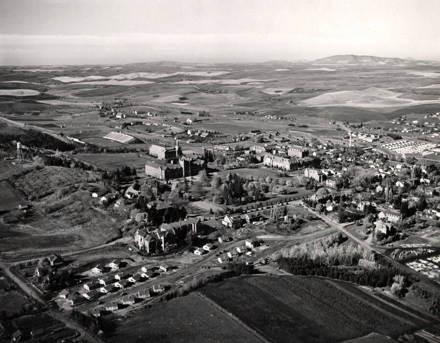1947 photograph of University of Idaho campus. Aerial view shows both campus and the surrounding fields. [PG1_003-28]