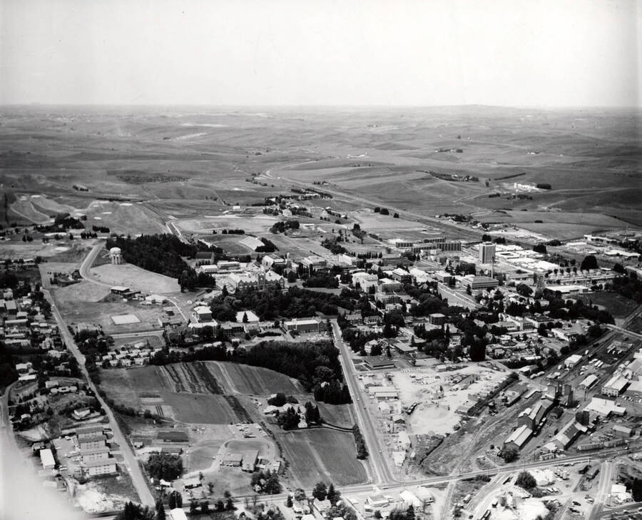 1961 photograph of University of Idaho campus. Aerial view shows both campus and the surrounding fields. [PG1_003-37]
