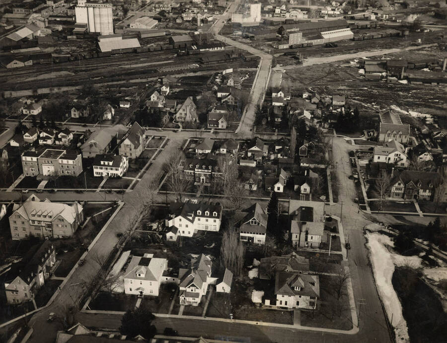 1915 photograph of University of Idaho campus. Aerial view shows railroad tracks. Picture has been torn in half and is taped together. [PG1_003-54]