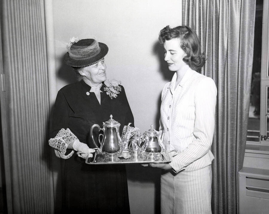 1953 photograph of Gifts. Mrs. A.A. Steel presenting silver service to Ethel Steel House representative Betty Ruth Westerberg. [PG1_400-02a]