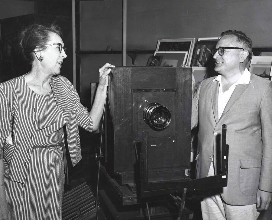 1965 photograph of Gifts. Charles Webbert and Ruth Ray examine a wodden camera [PG1_400-10]