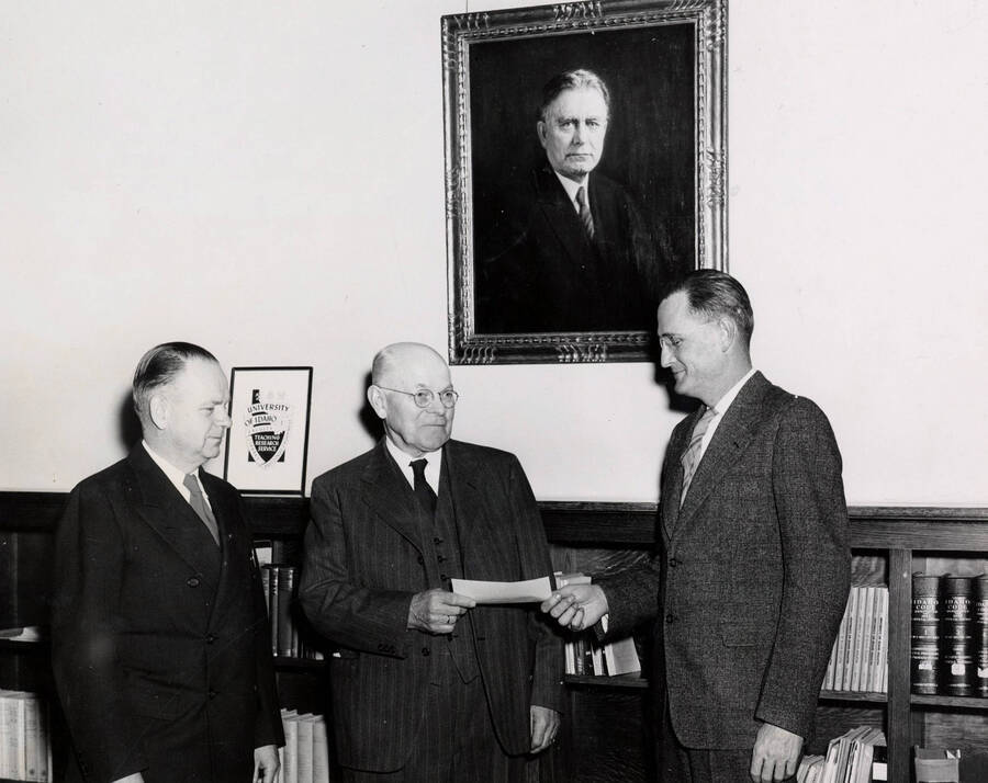 1947 photograph of Gifts. Alfred and Chris A. Hagen present a scholarship check to President J. E. Buchanan. [PG1_400-11]
