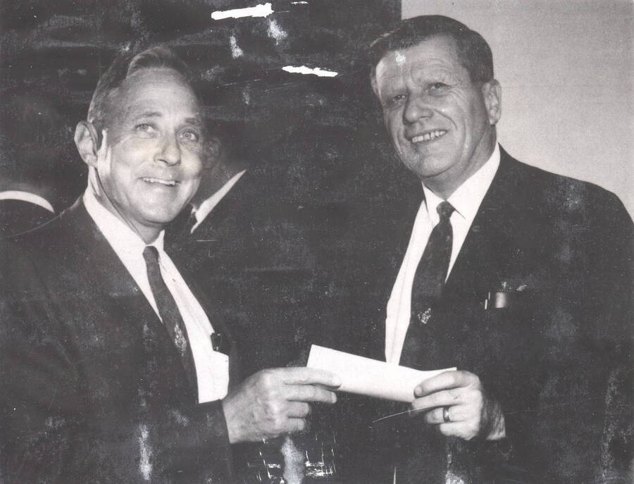 1968 photograph of Gifts. President Hartung receives a scholarship check from Robert Paine, the president of the Vandal Boosters Club. Donor: Publications Dept. [PG1_400-19]