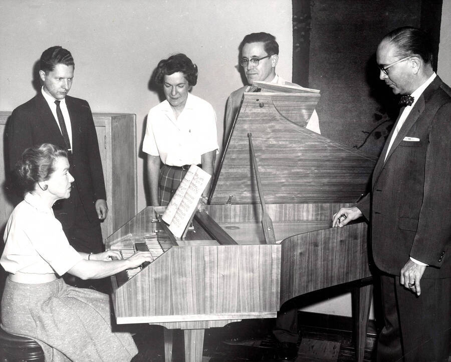 1952 photograph of Gifts. l-r: Agnes Schuldt, Steven Romanio, Marian Frykman, Bruce Bray, and Hall Macklin gethered around a harpsichord. Donor: Publications Dept. [PG1_400-20]
