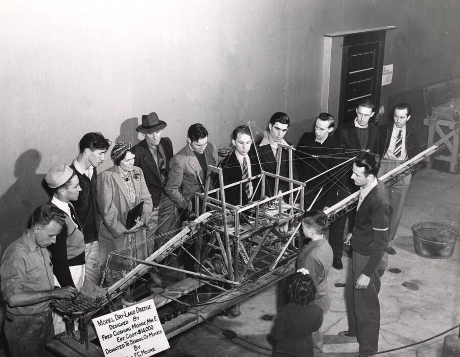 1940 photograph of Gifts. People examining a model of a dry-land dredge. Design by Fred Cushing Moore. [PG1_400-28]