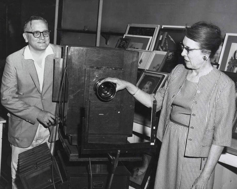 1965 photograph of Gifts. Charles Webbert and Ruth Ray examine a wodden camera. [PG1_400-09]