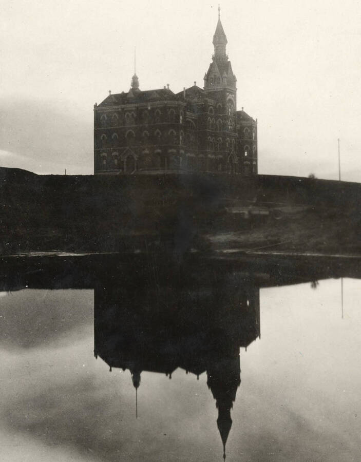 1894 photograph of Administration Building. View of the old Administration building reflected in the water. [PG1_51-02a]