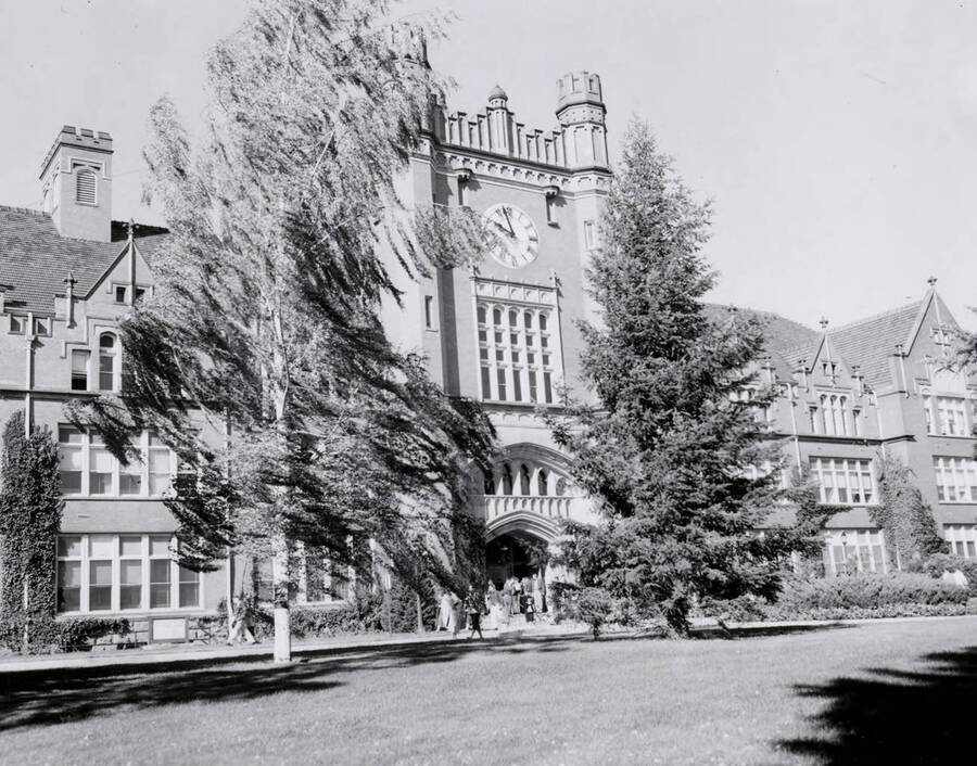 1950 photograph of Administration Building. View of clock tower and students. [PG1_52-068b]