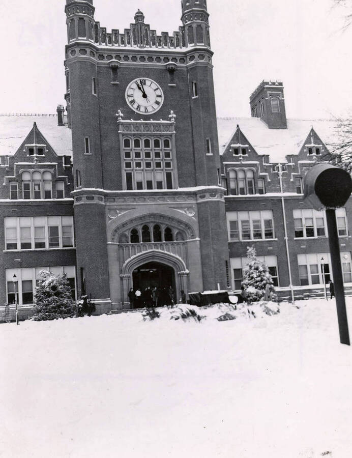 1945 photograph of Administration Building hand tinted. View of the clock tower in winter. [PG1_52-177]