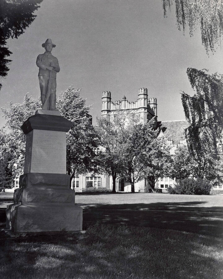 1941 photograph of Administration Building hand tinted. View of Spanish-American War Memorial statue. [PG1_52-179]