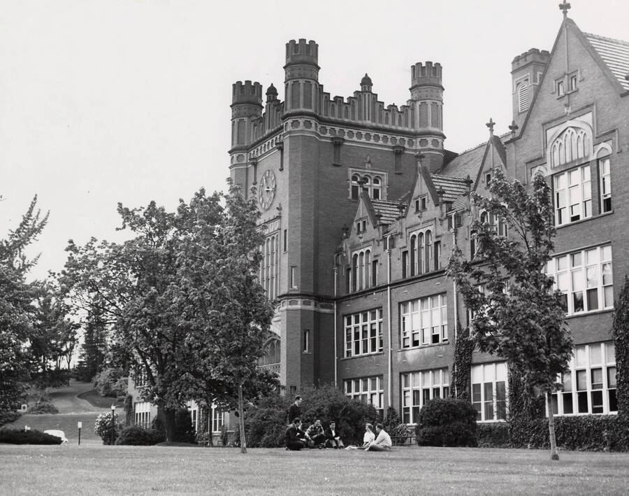 1948 photograph of Administration Building. Students shown sitting on the lawn. Donor: Publications Dept. [PG1_52-090]
