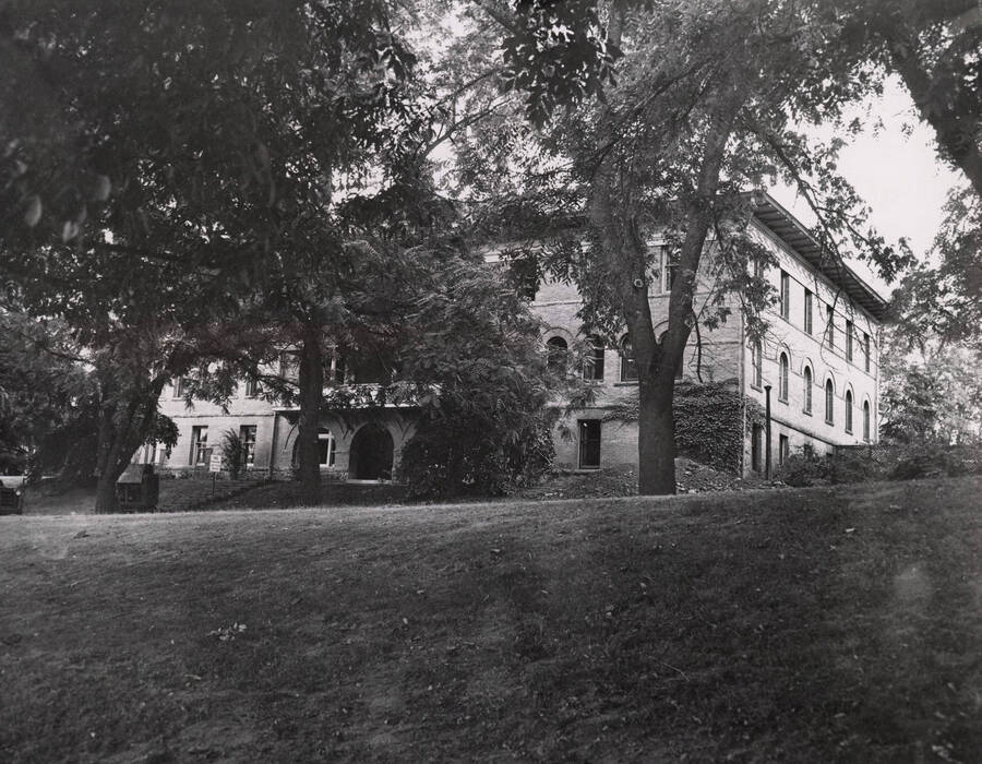 1911 photograph of Ridenbaugh Hall. View from across the lawn seen through the trees. [PG1_58-19]