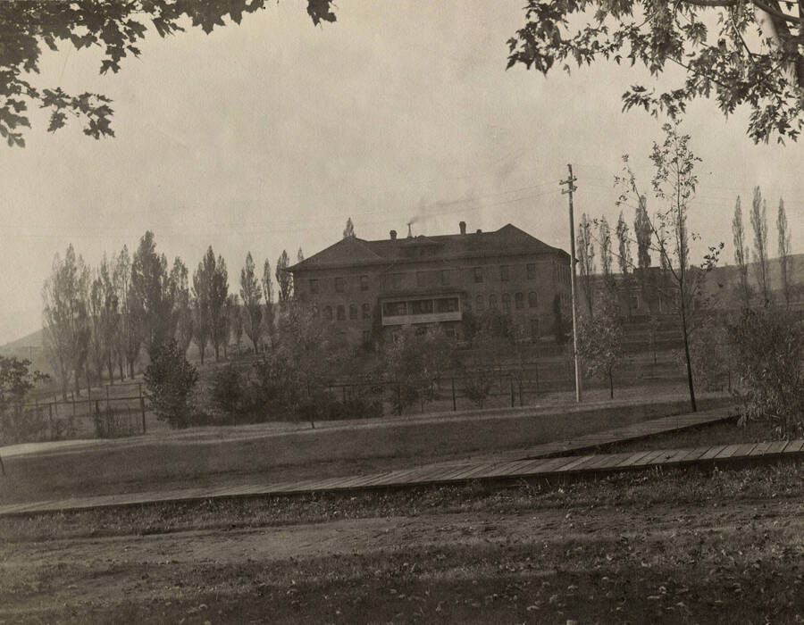1908 photograph of Ridenbaugh Hall. View of the wooden sidewalks. [PG1_58-08]