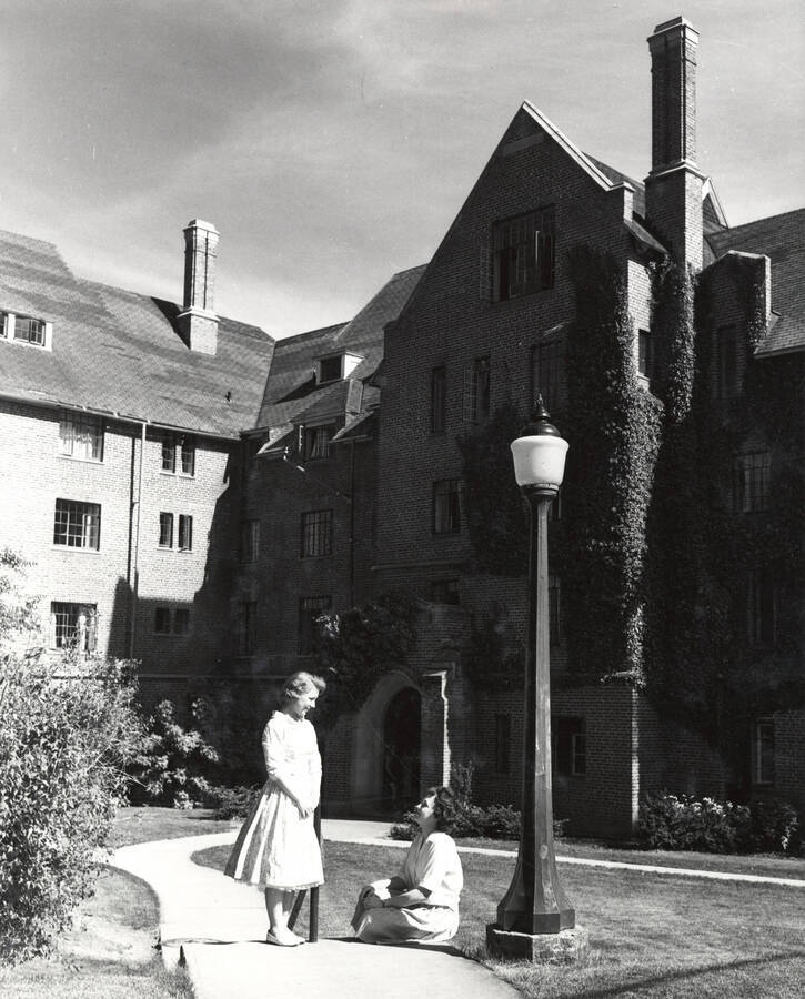 1954 photograph of Hays Hall. Students shown sitting on steps. Donor: Publications Dept. [PG1_59-15]