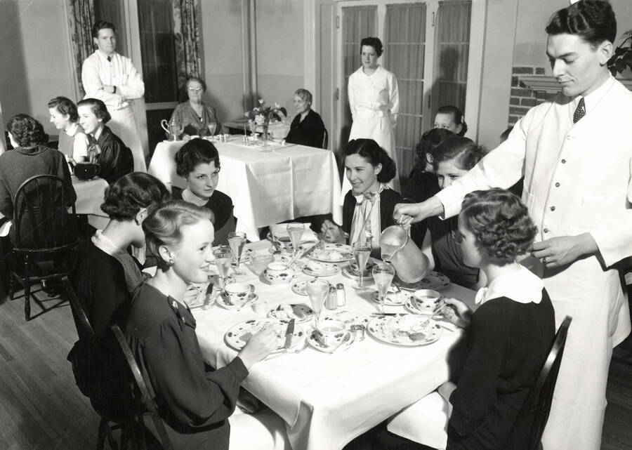 1936 photograph of Hays Hall. View of the women in their dining room along with servers. [PG1_59-09]