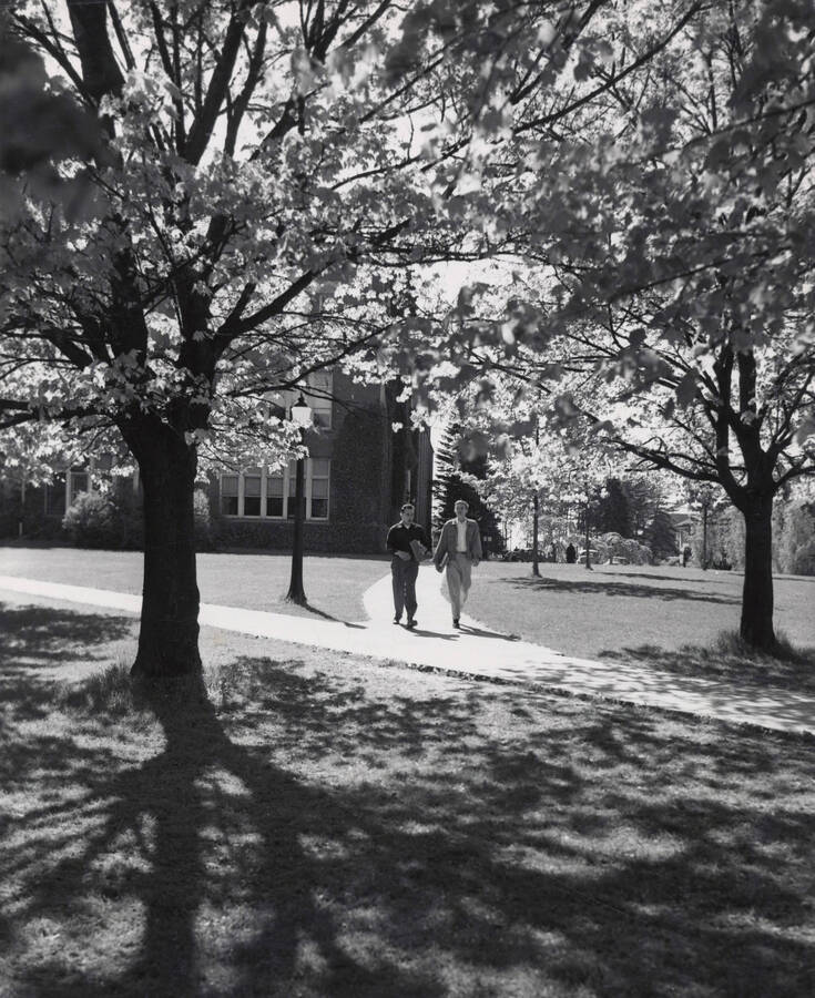 1942 photograph of University of Idaho campus scenery. Students showed walking to class. Donor: Publications Dept. [PG1_006-04]