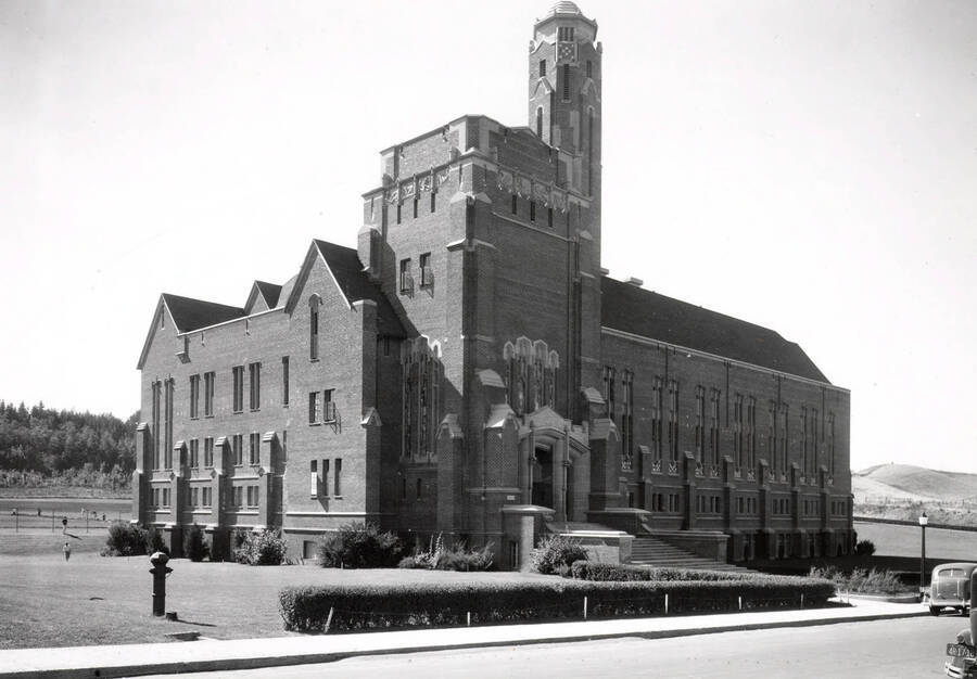 1933 photograph of Memorial Gymnasium. View of the northeast corner with automobiles in front. [PG1_61-10]