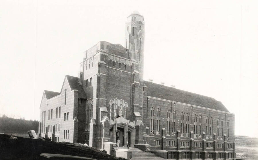 1928 photograph of Memorial Gymnasium. View of students next to building entrance. [PG1_61-04]