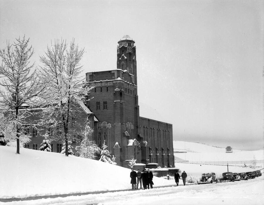 1935 photograph of Memorial Gymnasium. View of winter scene, students on walkway. [PG1_61-40]