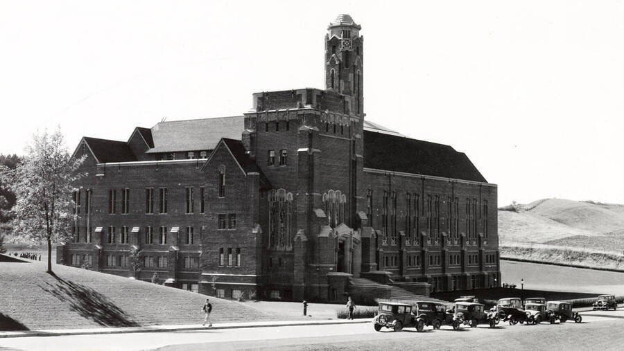 1930 photograph of Memorial Gymnasium. View of the northeast corner with automobiles in front. [PG1_61-09]
