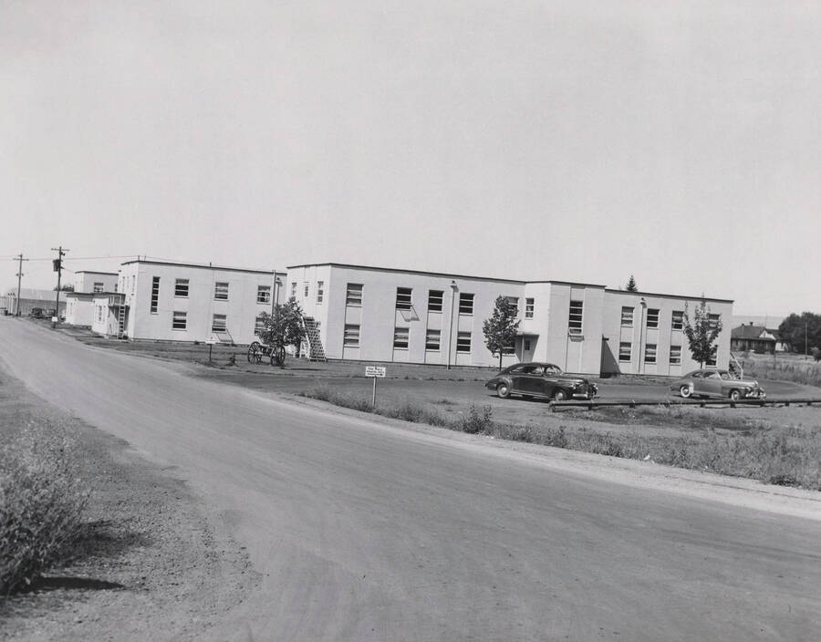 1947 photograph of Pine Hall. View from the street of automobiles with cannon out front. [PG1_64-01]