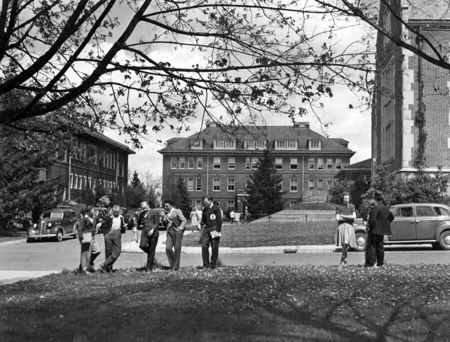 1933 photograph of Morrill Hall. View of students leaning against a fence. [PG1_66-14]